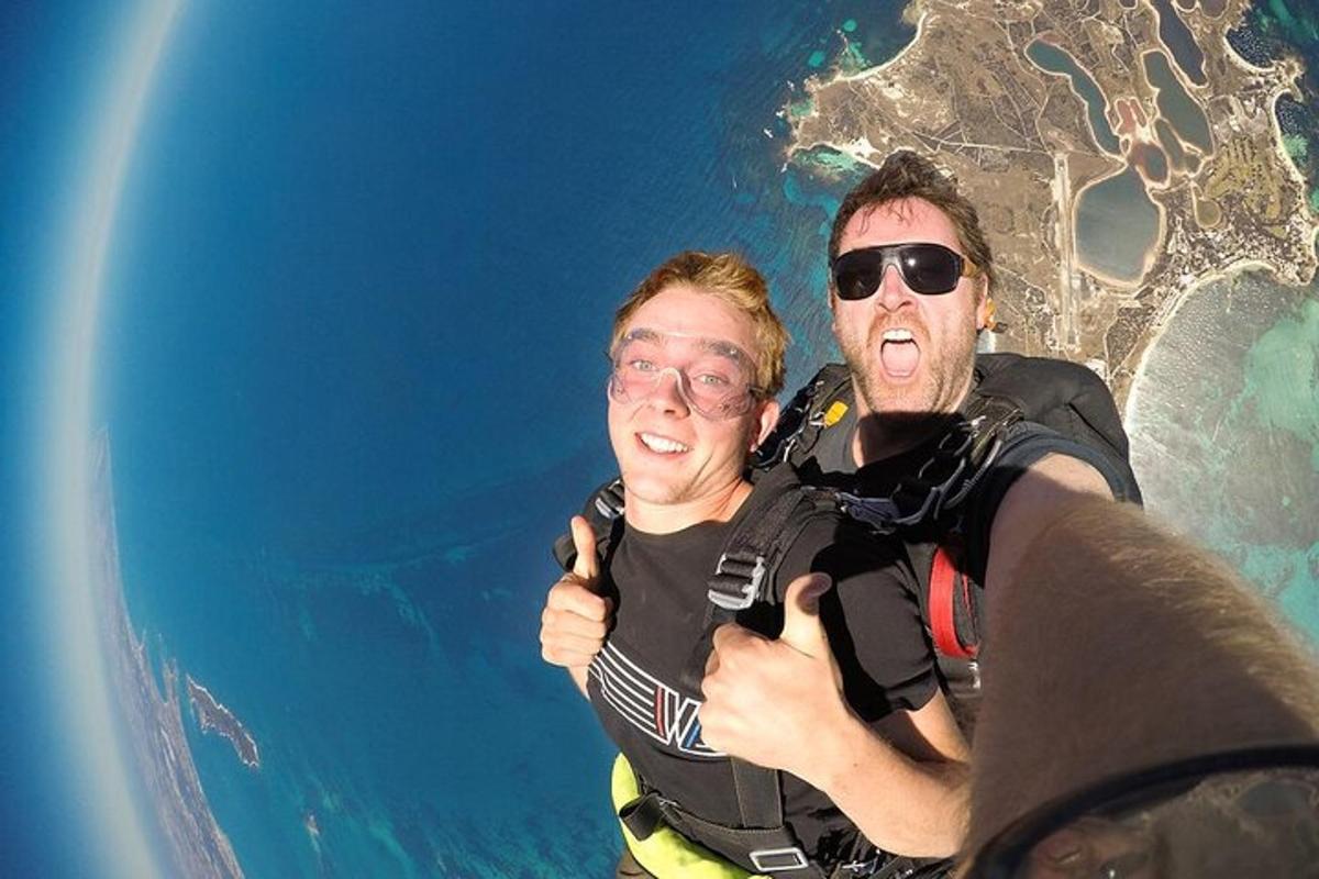 dva lidé ukazují palec nahoru při letu nad oceánem