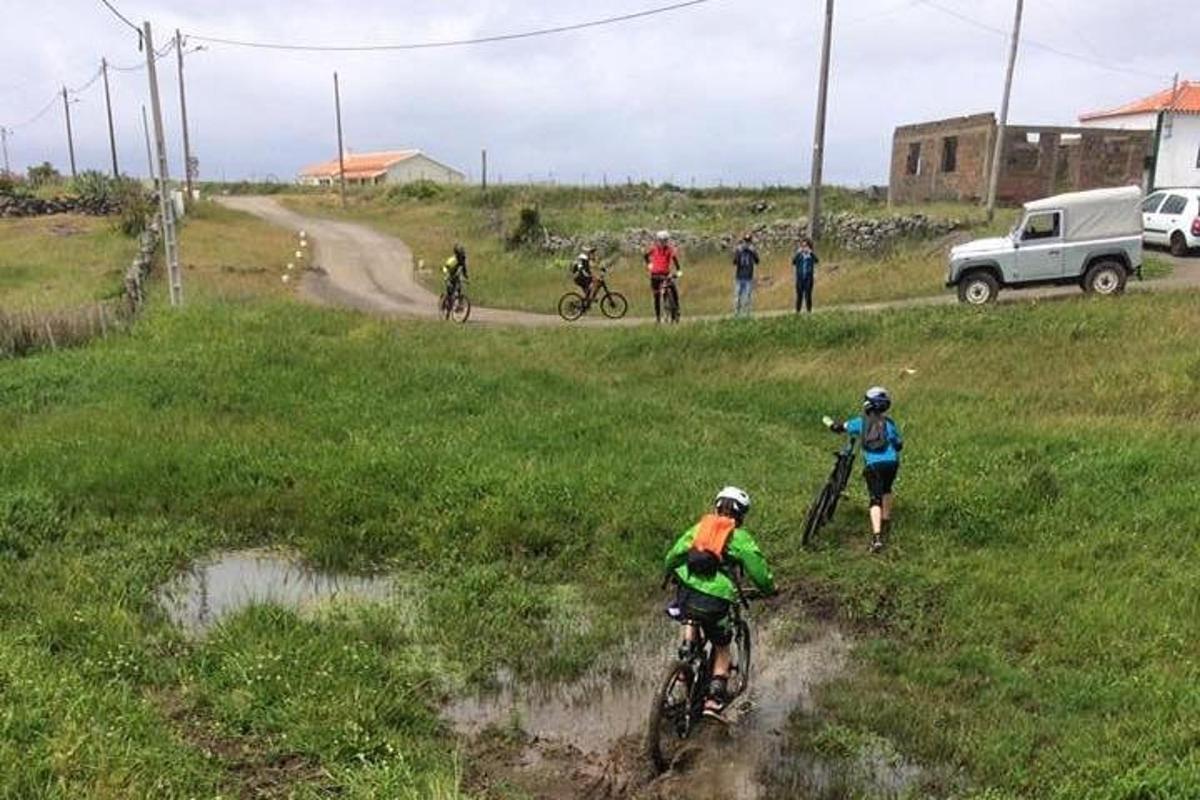 een groep mensen die op hun fiets over een onverharde weg rijden