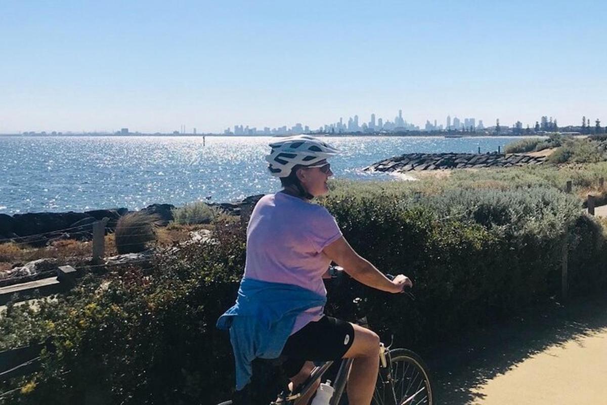 a woman riding a bike on a path near the water
