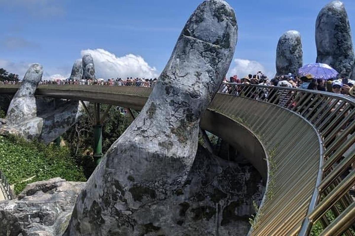tangan batu besar menghulurkan ke atas jambatan