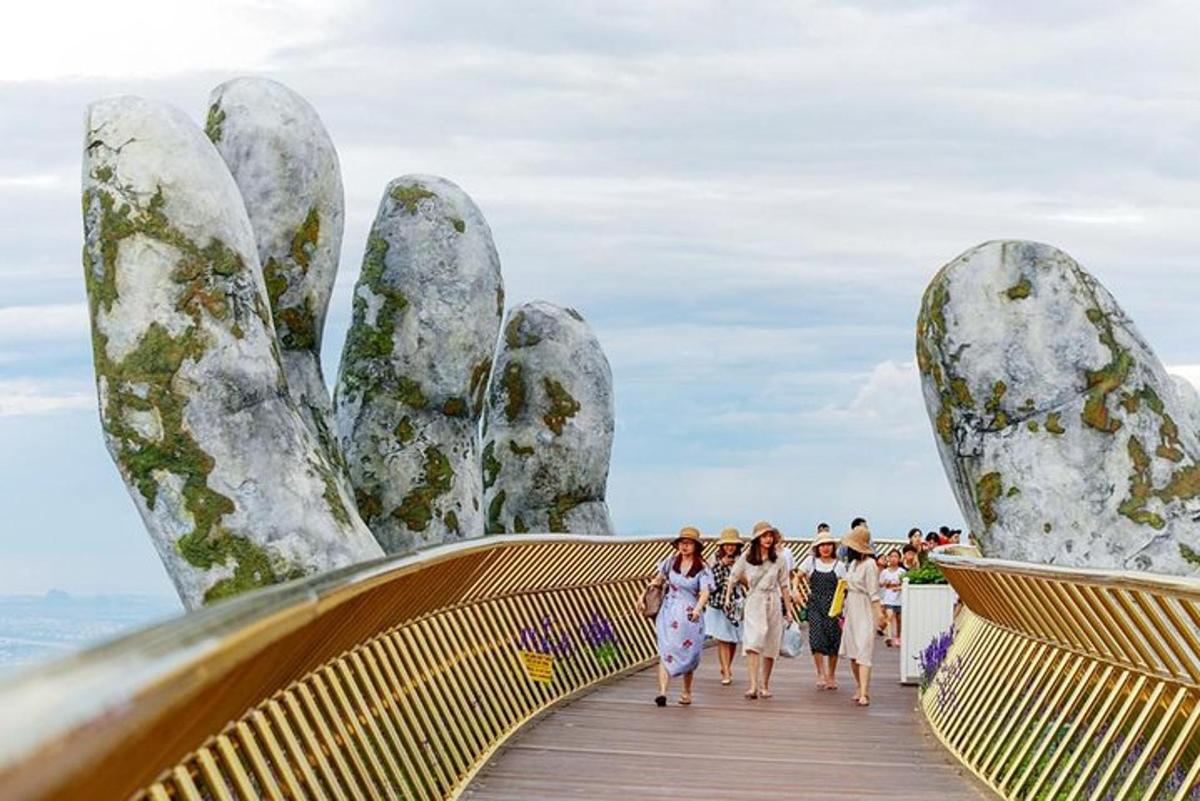 un gruppo di persone che camminano su un ponte con grandi mani di pietra
