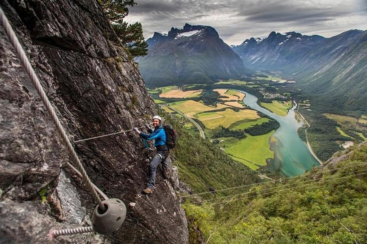 en man som står på en zipline på ett berg