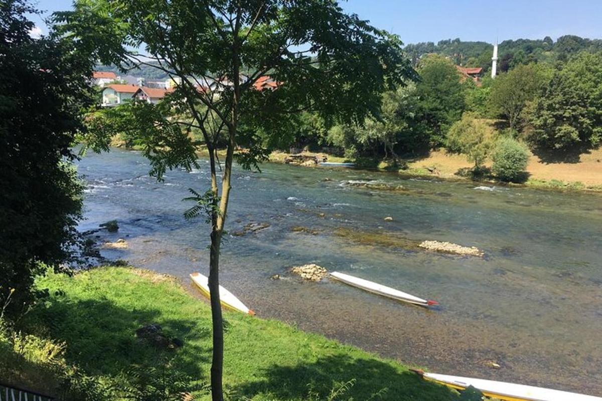 a river with several surfboards laying on the shore