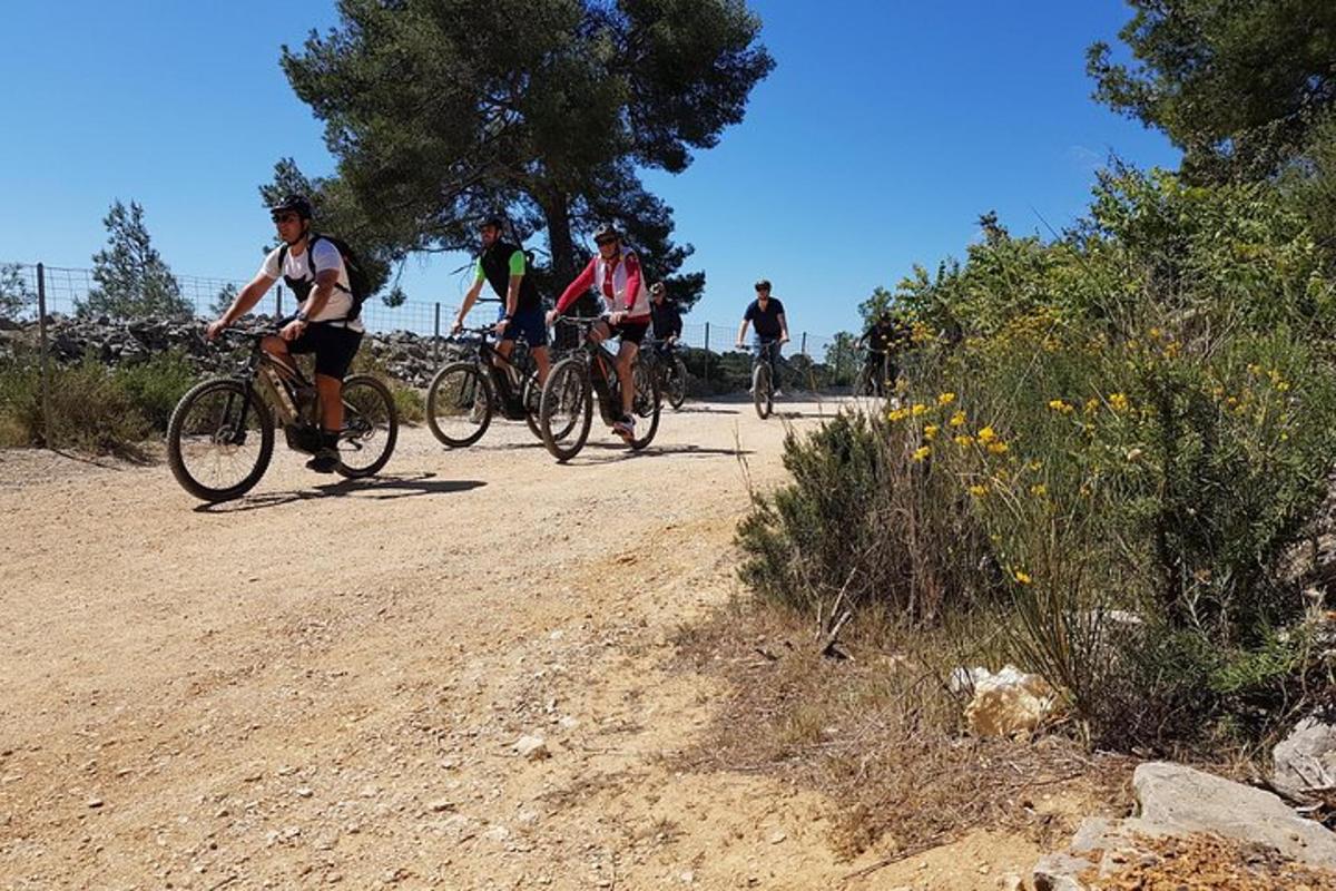 un gruppo di persone in bicicletta su una strada sterrata