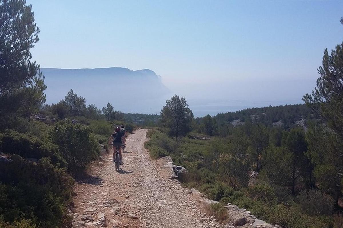una persona che va in bicicletta lungo una strada sterrata