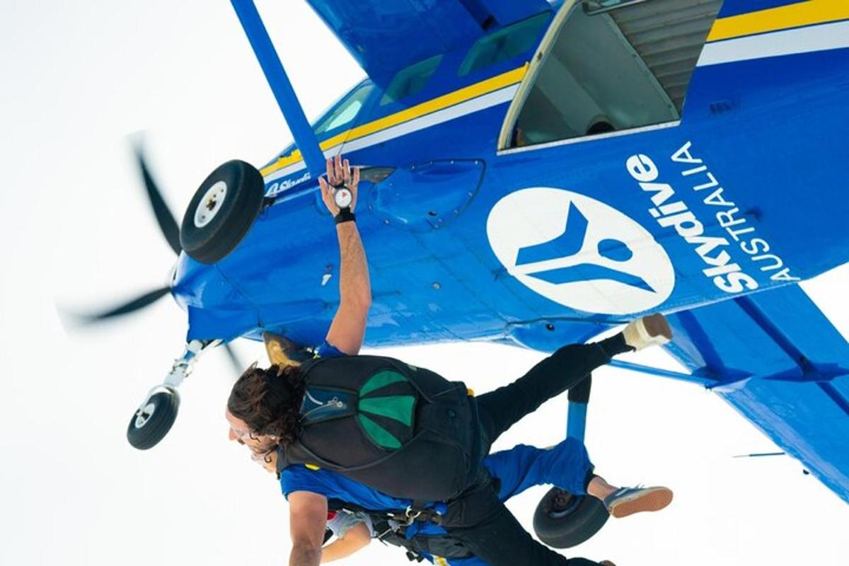 a person is hanging off the wing of a plane