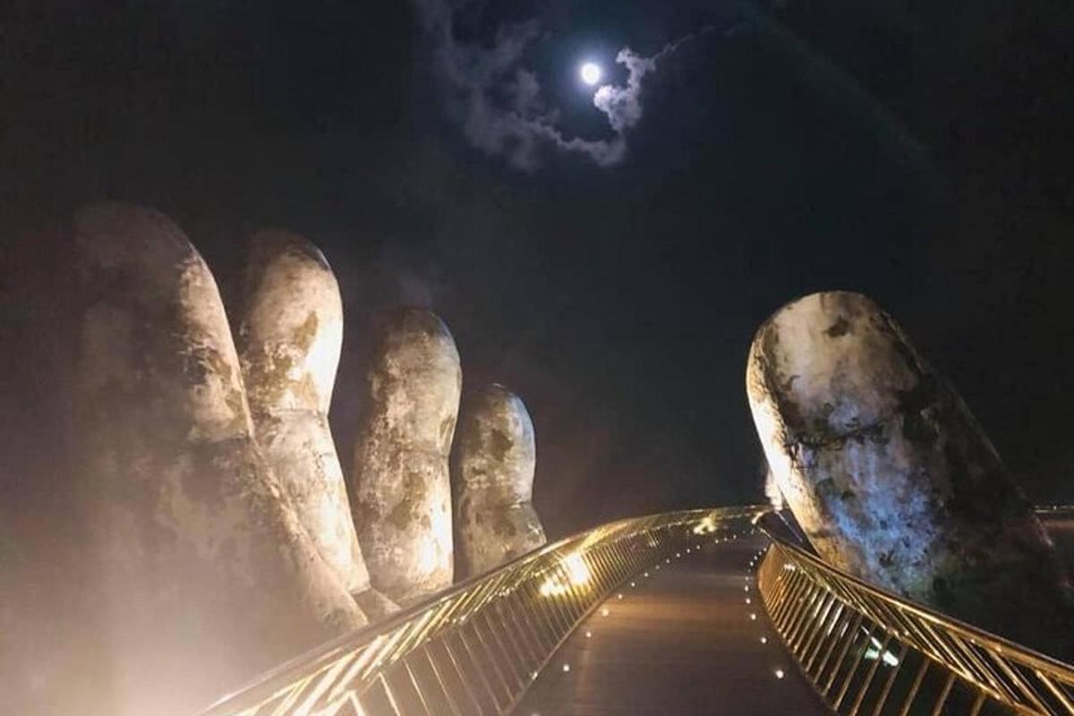 a view of a statue at night with the moon