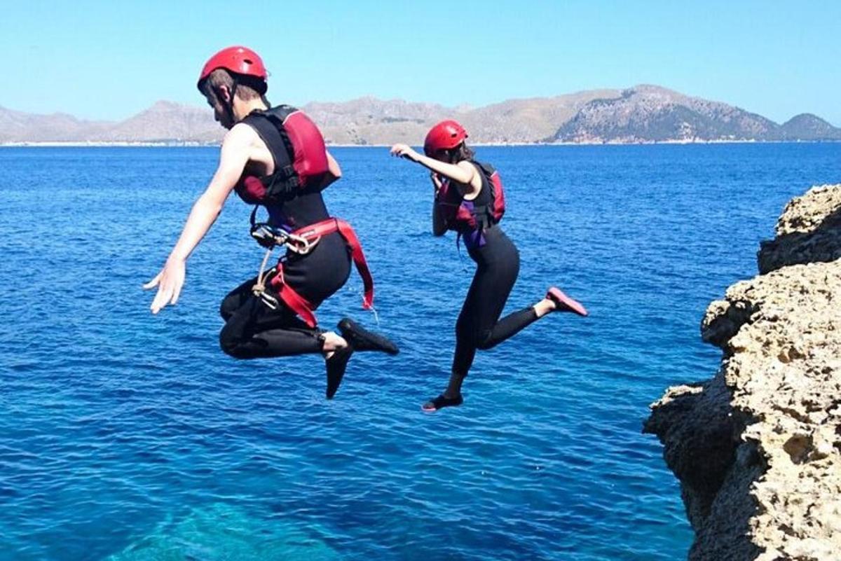 due persone che saltano dalle rocce in acqua