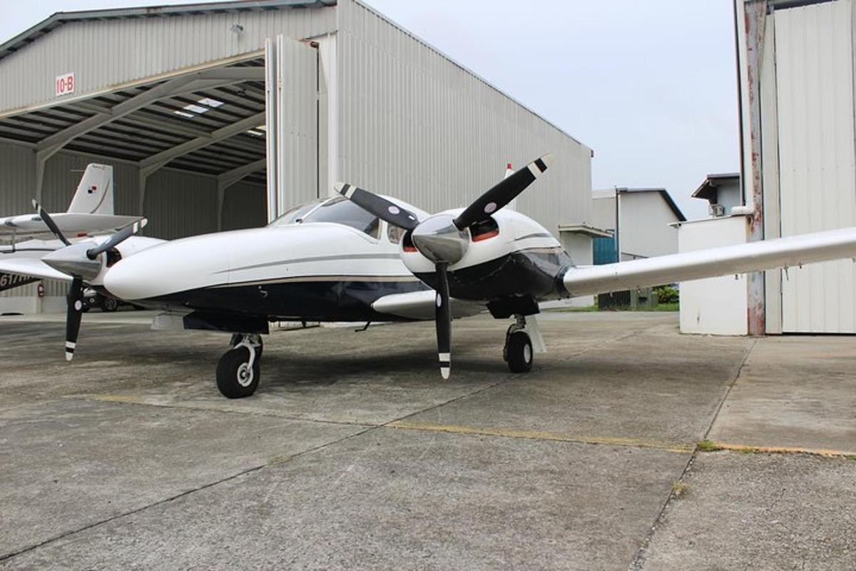 a small propeller plane parked in front of a hangar