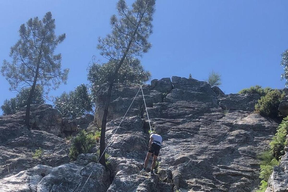 un uomo in piedi sulla cima di una montagna rocciosa