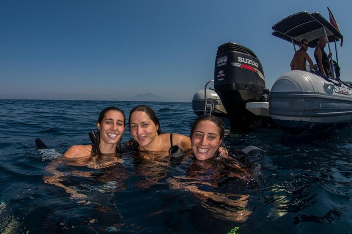 tre donne in acqua accanto a una barca