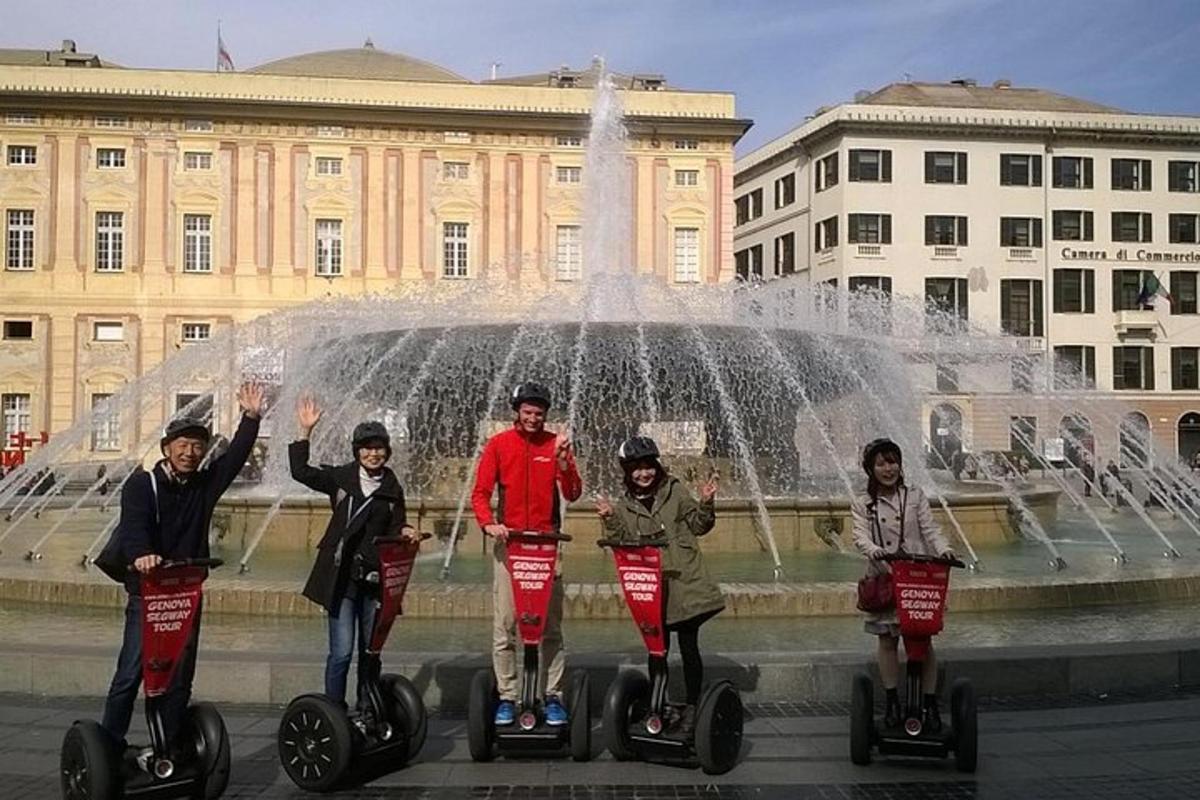 Skupina lidí jezdících na segwayích před fontánou