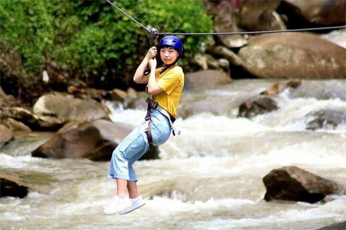 seseorang sedang melompat di sungai dengan zip line
