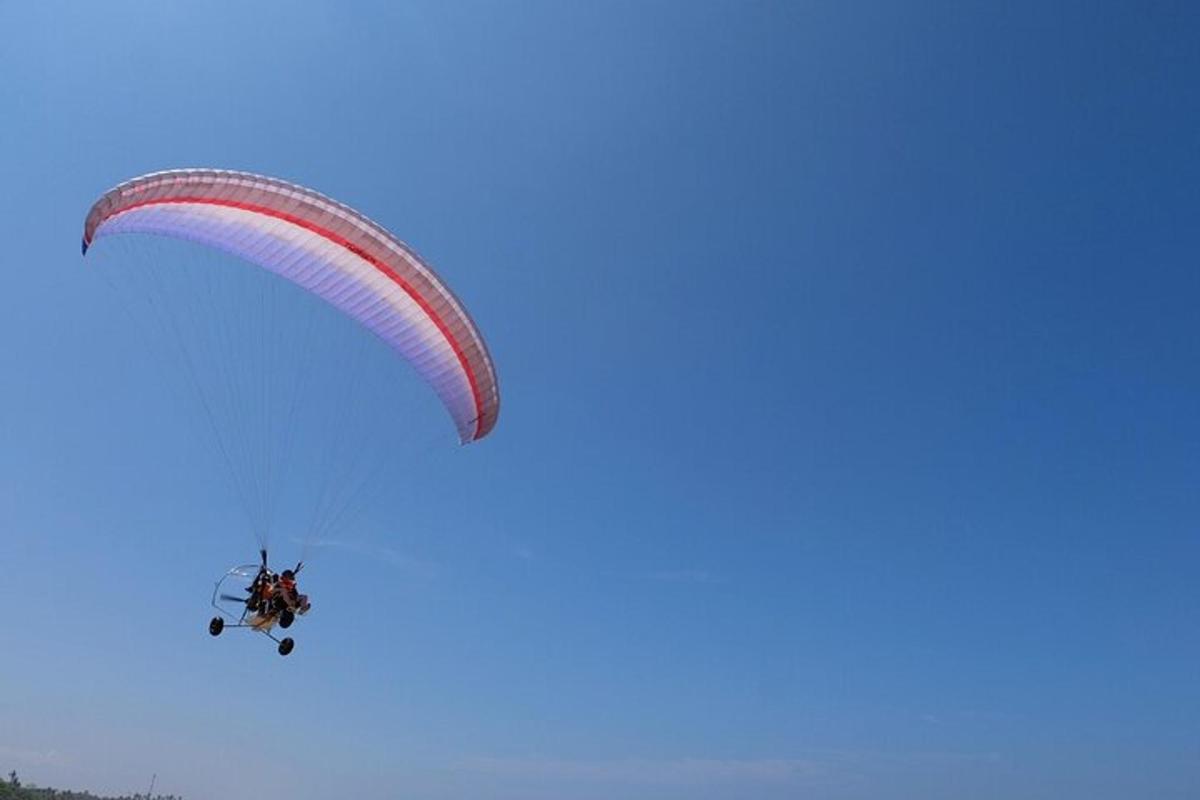 a person riding a parachute in the sky