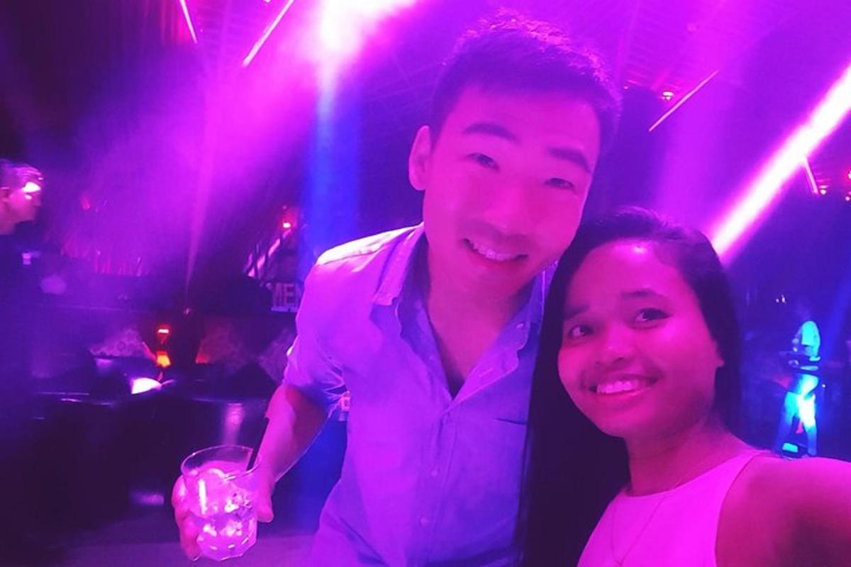 un uomo e una donna posano per una foto in una discoteca