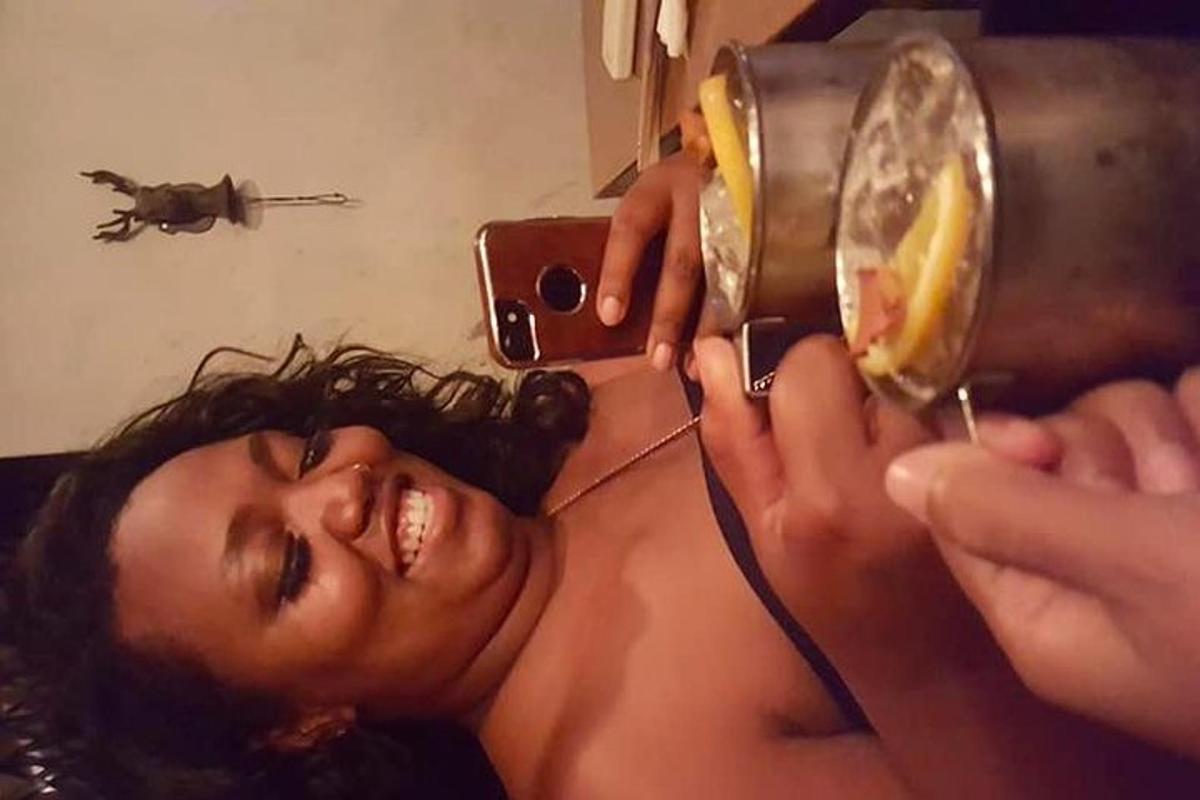 uma mulher cortando o cabelo com um secador de cabelo