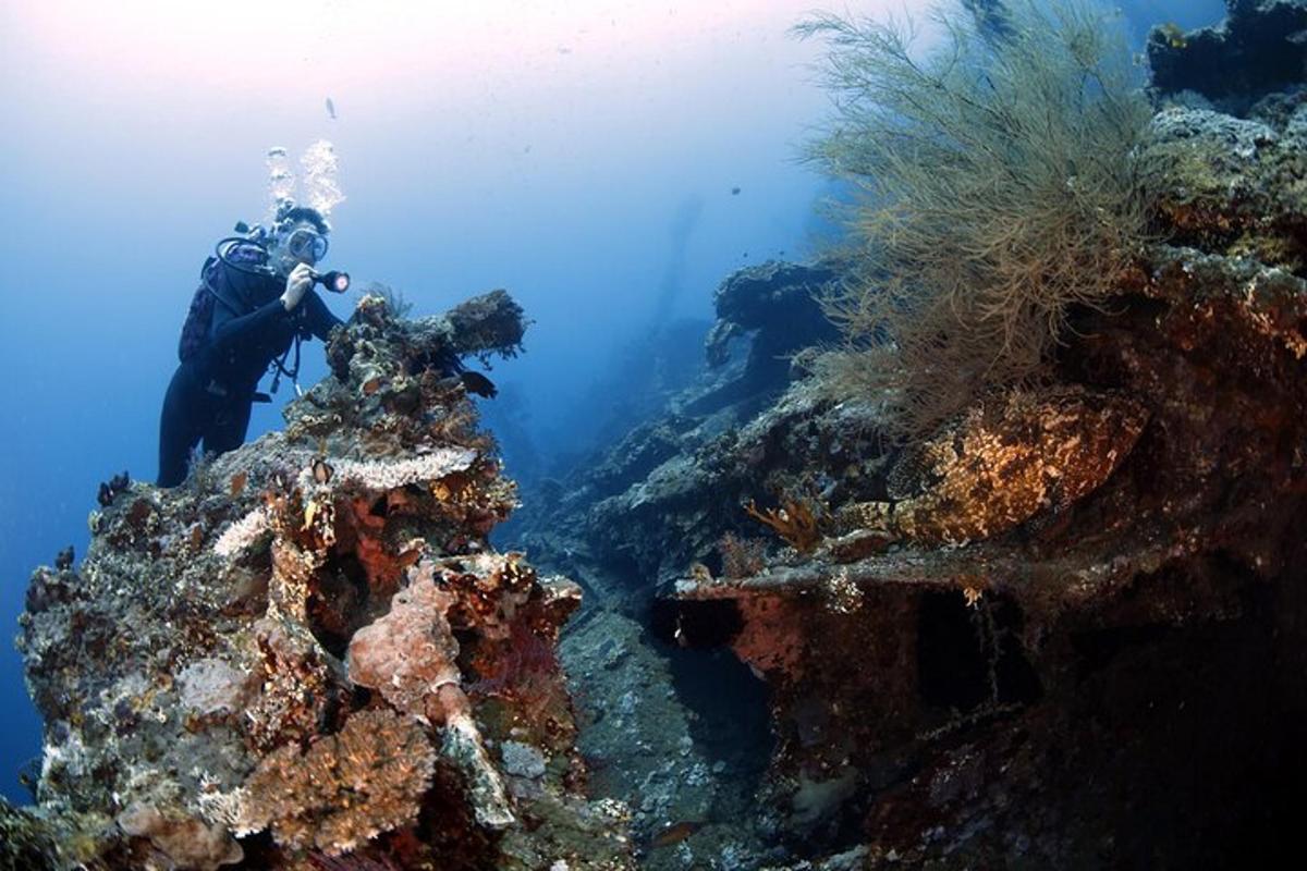 oseba v oceanu, ki fotografira greben