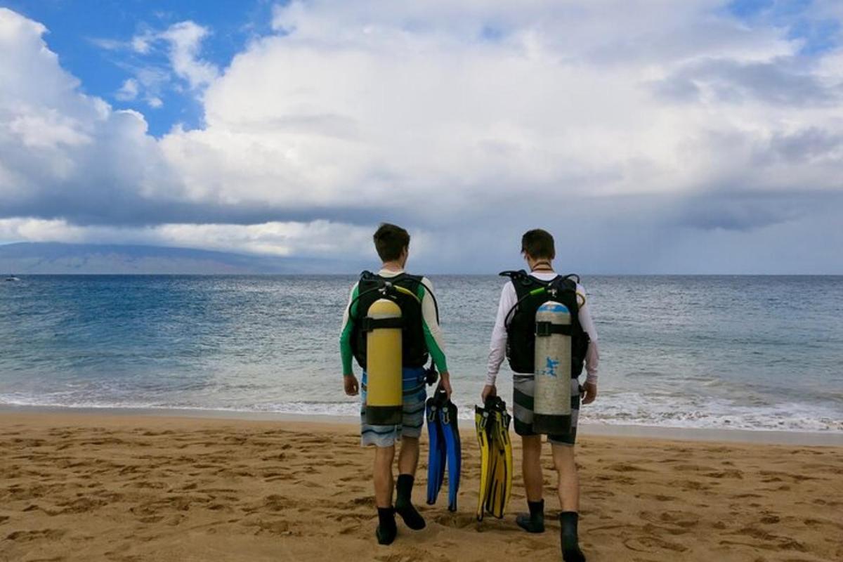 Dos jóvenes de pie en la playa con tablas de surf