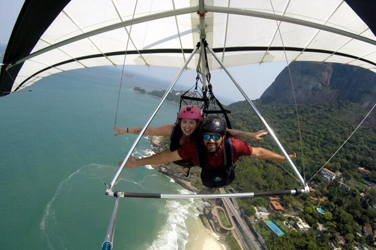 two people hanging from a parachute over the water