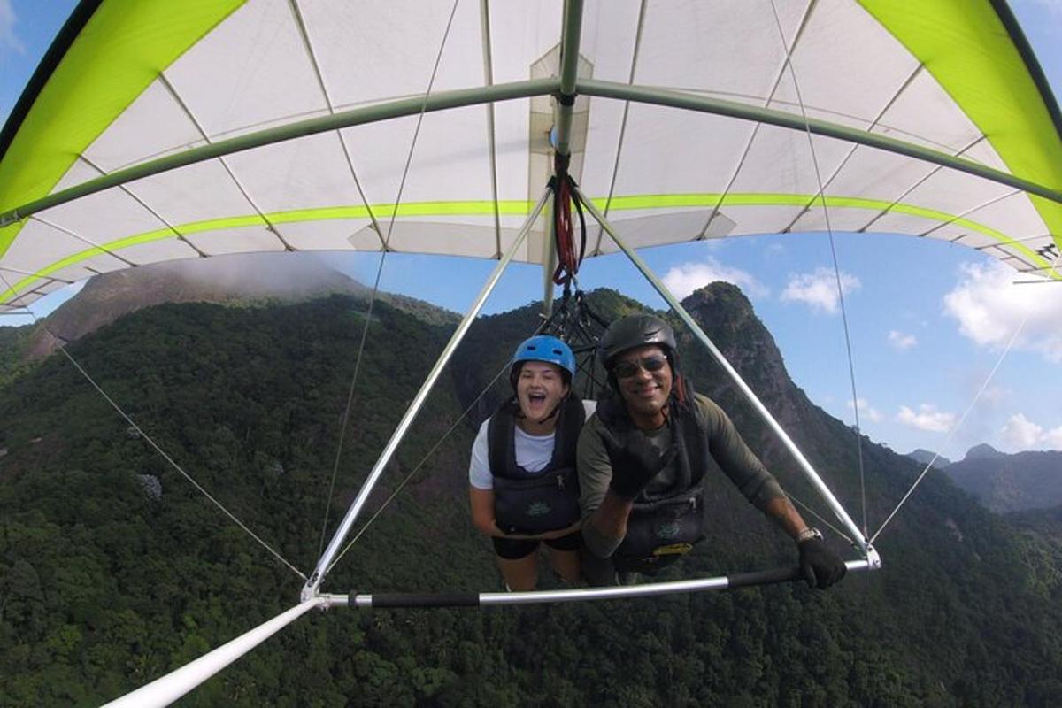 two people riding on a parachute in the mountains