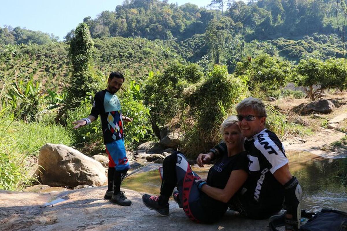 un gruppo di persone sedute su una roccia vicino a un fiume