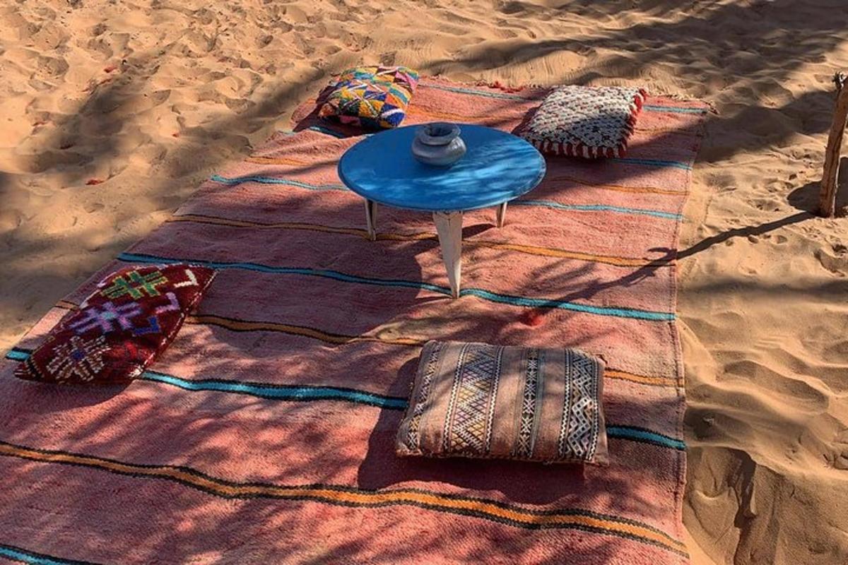 بطانية على الشاطئ مع طاولة ووسائد