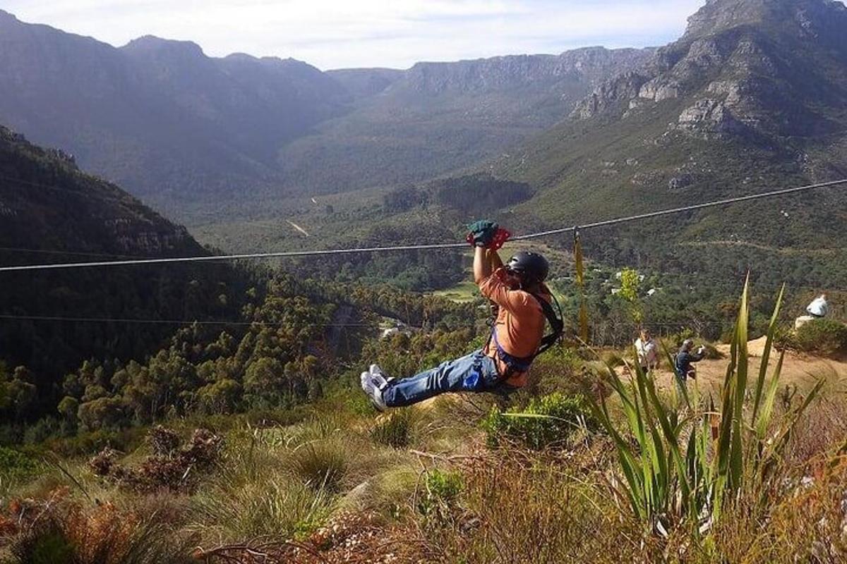 um homem está pulando em uma tirolesa em uma montanha