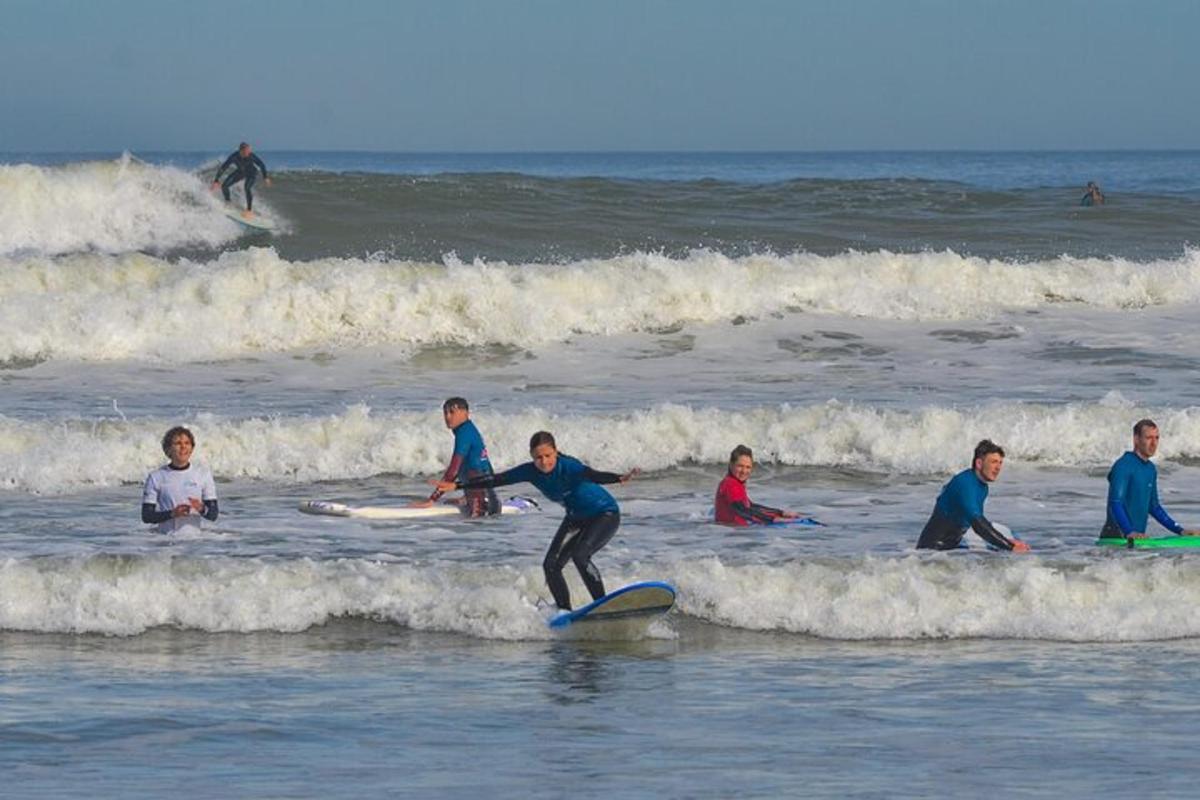 skupina lidí jezdících na vlnách na surfových prknech v oceánu