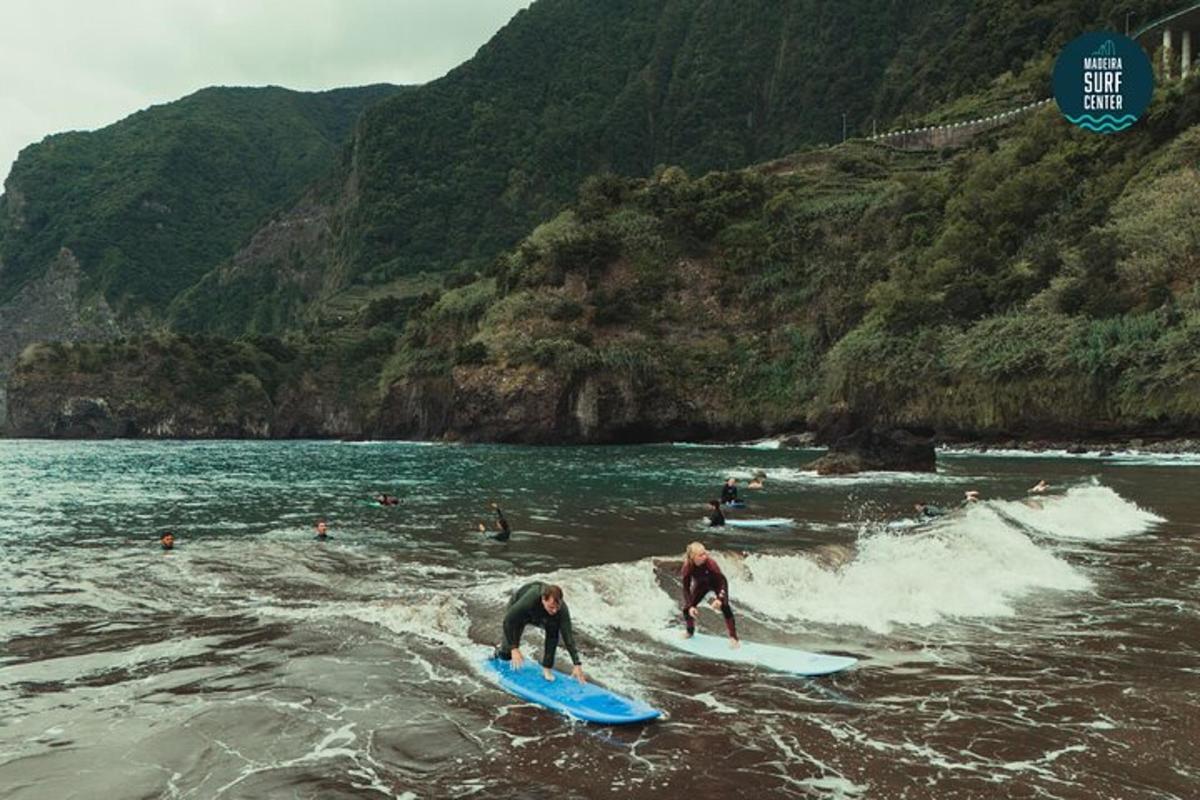 duas pessoas em pranchas de surfe na água em uma praia