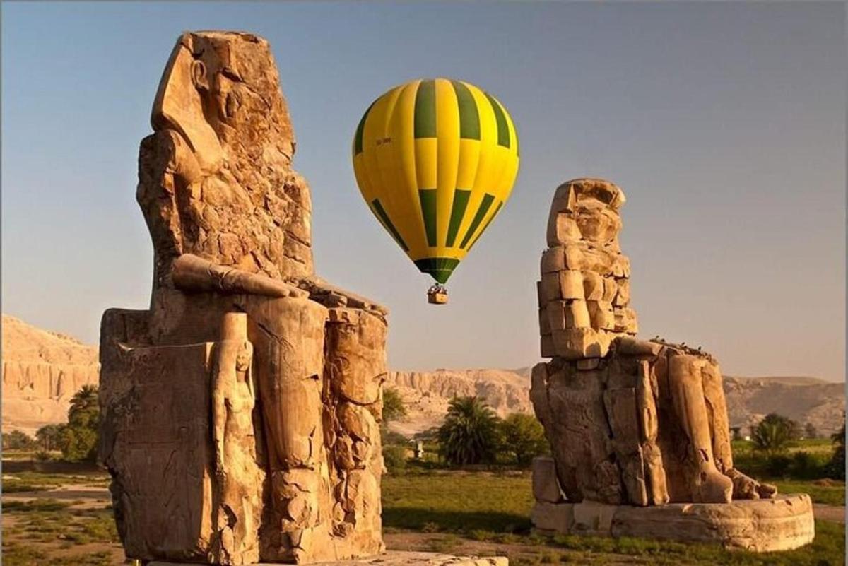 una mongolfiera che vola sopra una statua