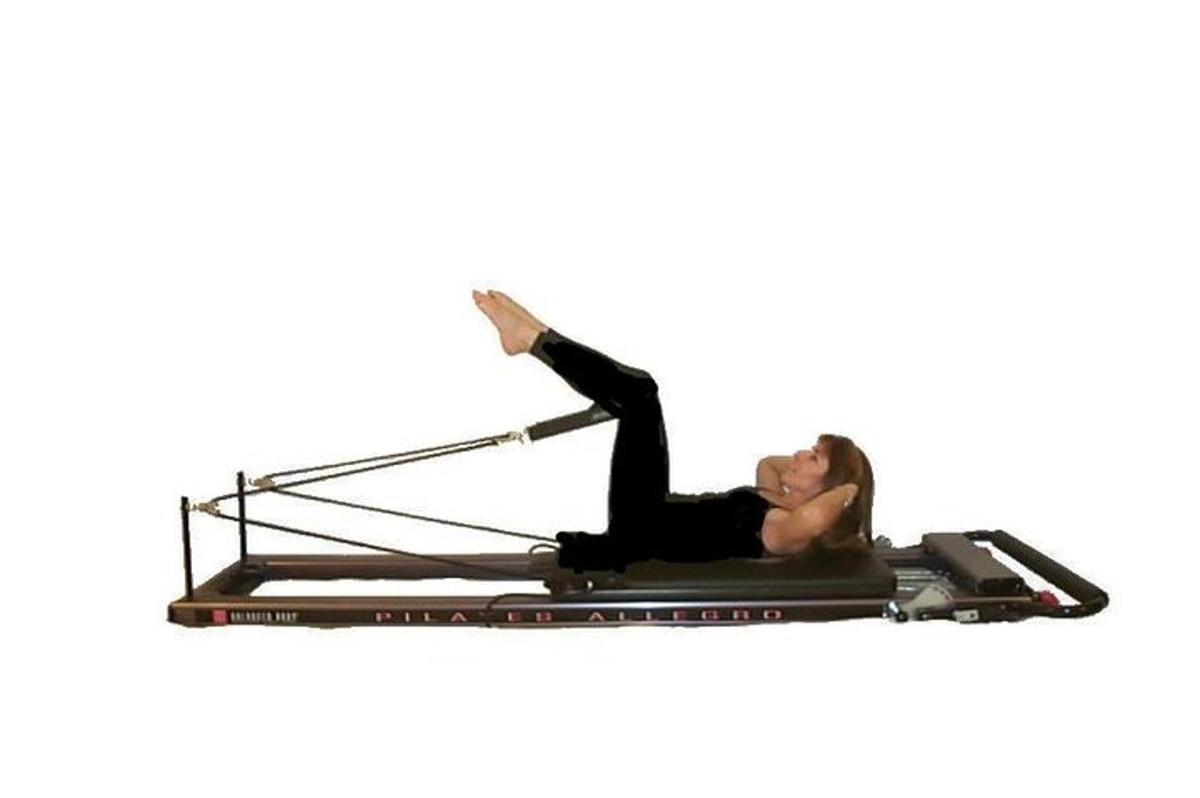egy nő pilates reformeren fekszik