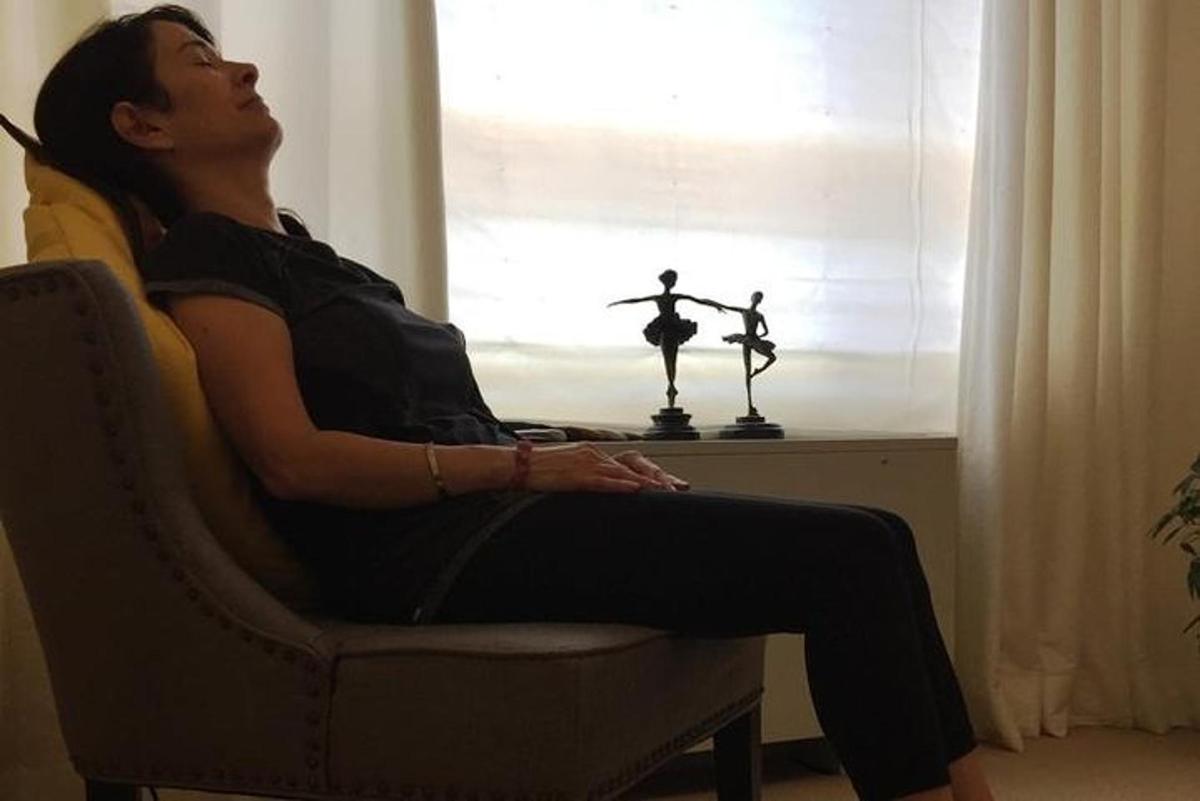 una donna seduta su una sedia accanto a una finestra