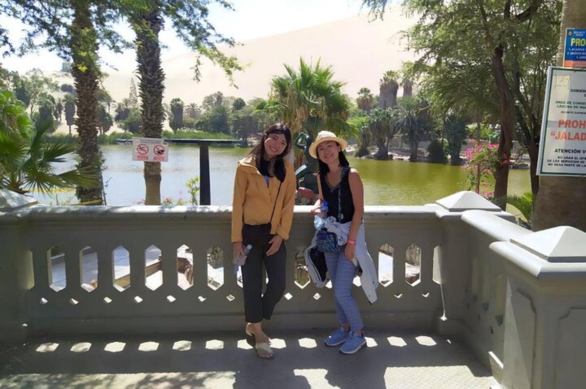 due donne in piedi su un ponte di fronte a uno stagno