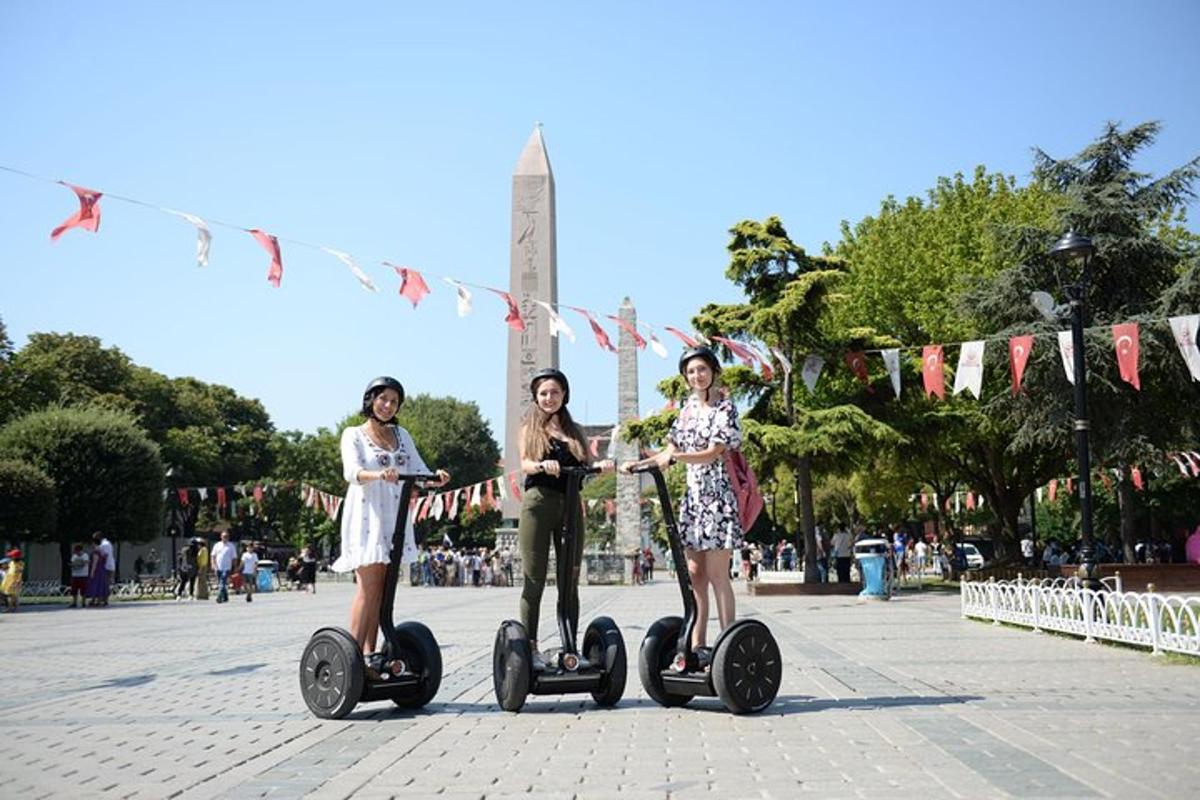 Tři dívky jezdí na segwayích na náměstí