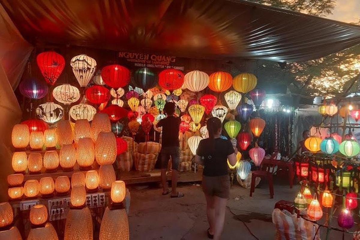 a group of people standing in front of a market with lanterns