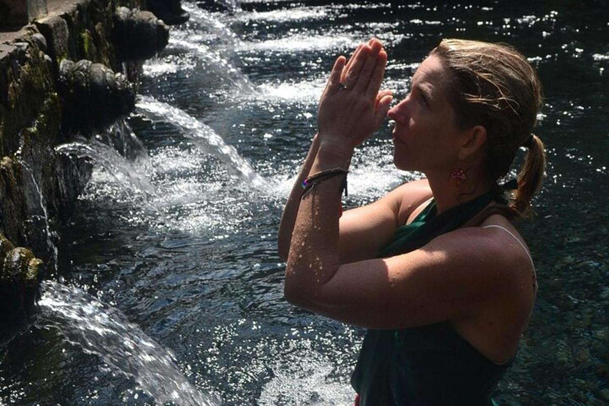 a woman standing in front of a waterfall