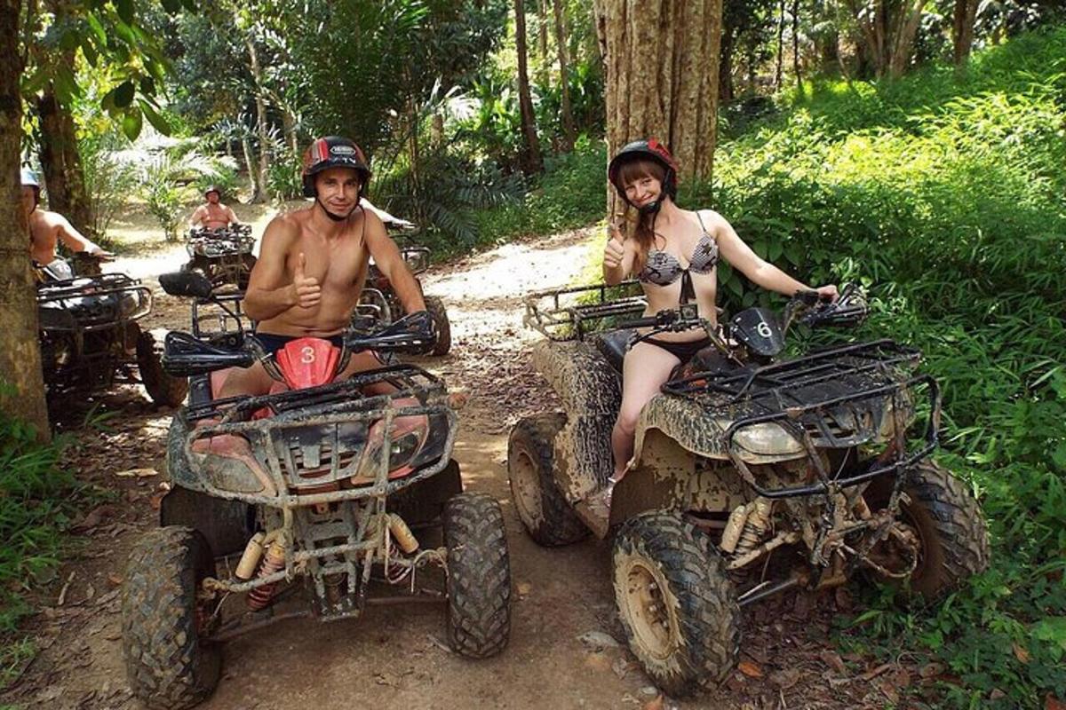 seorang pria dan wanita duduk di atas ATV di jalan setapak