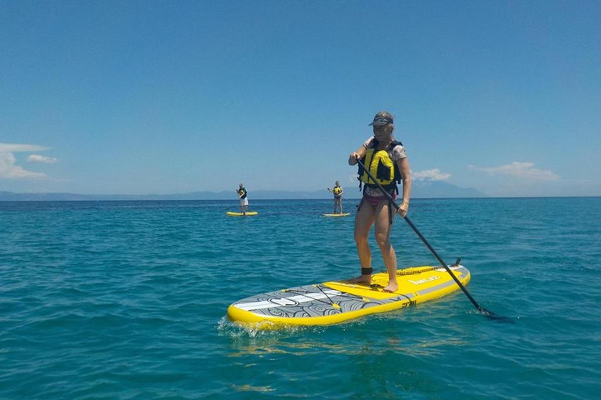 een man die op een paddleboard in de oceaan staat