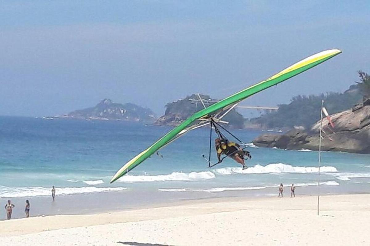 seseorang menerbangkan layang-layang besar di pantai