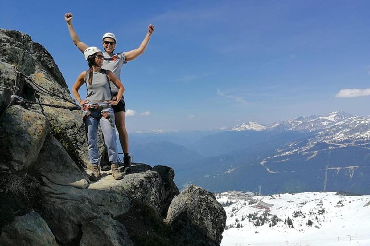 tveir menn standa á fjallstindi