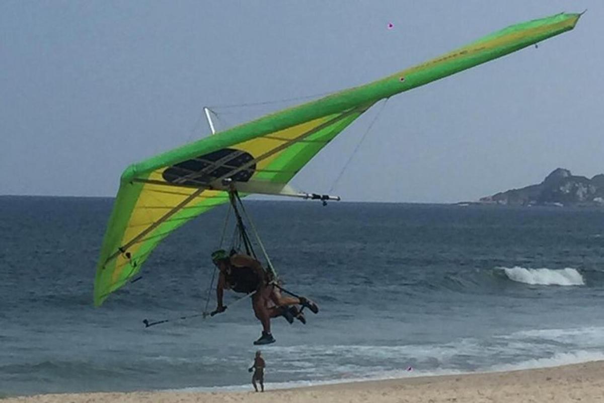 seorang lelaki menerbangkan layang-layang di pantai