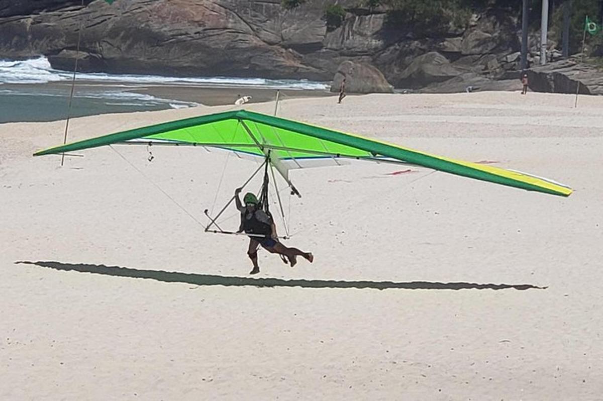 en mand løber under en grøn drage på stranden