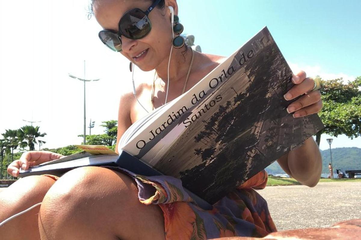 a woman sitting on the ground reading a book