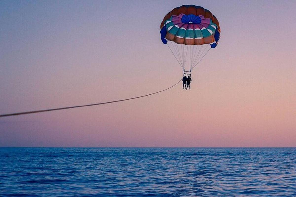 a person on a parachute flying over the ocean