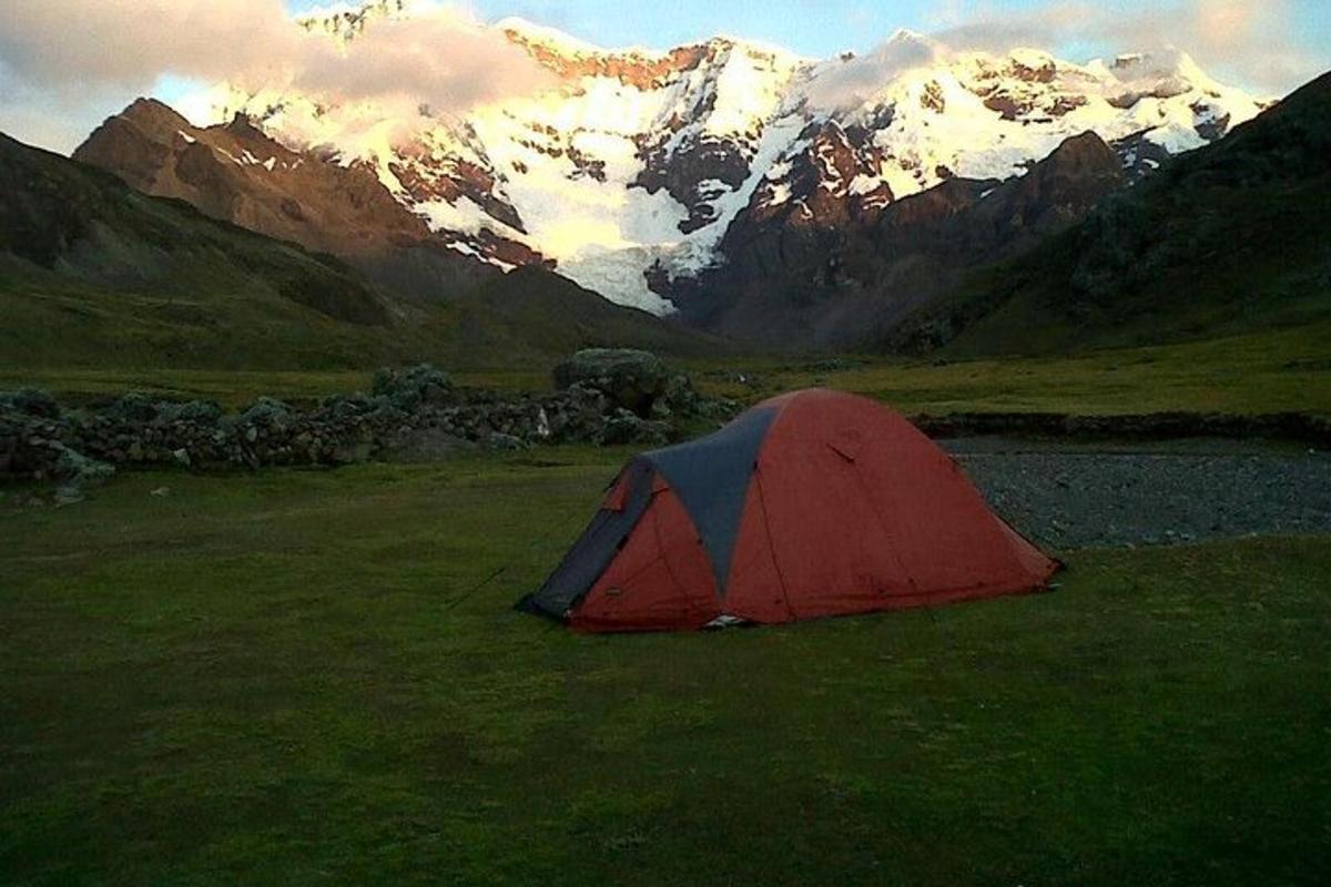 una tenda rossa e blu in un campo con montagne