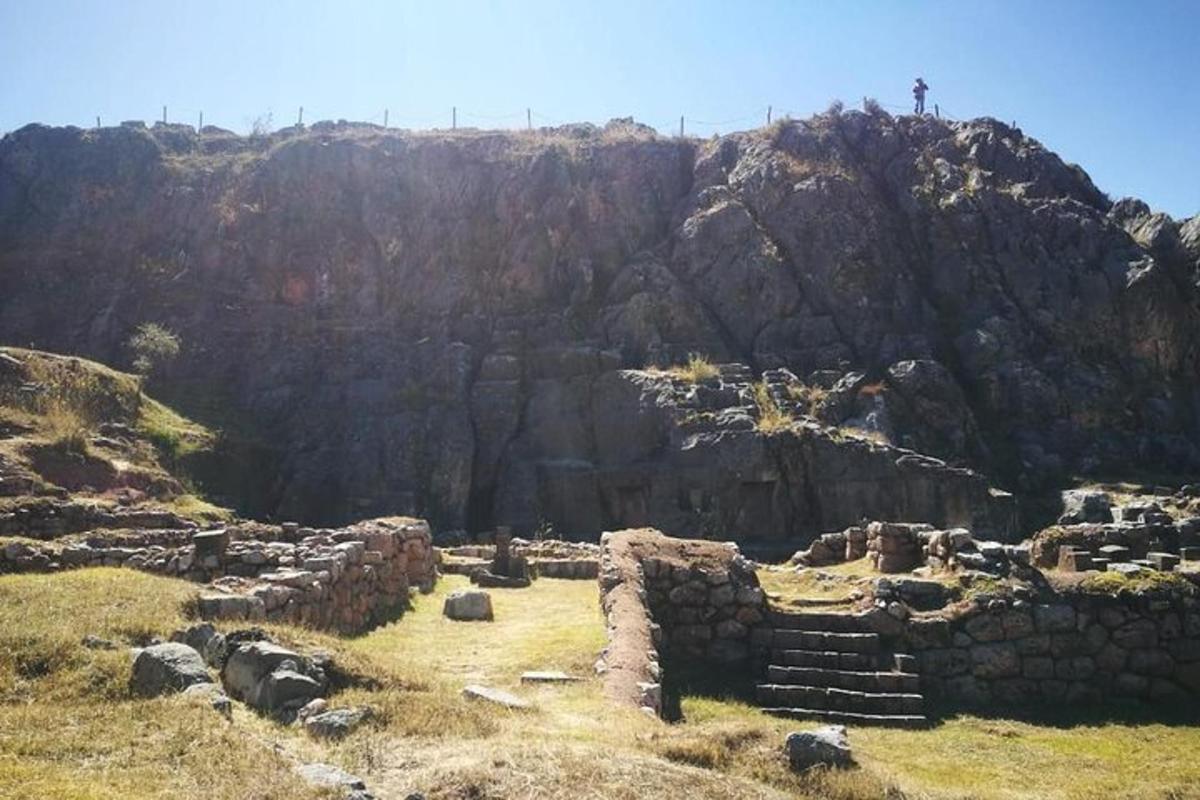 osoba stojící na vrcholu skalnaté hory