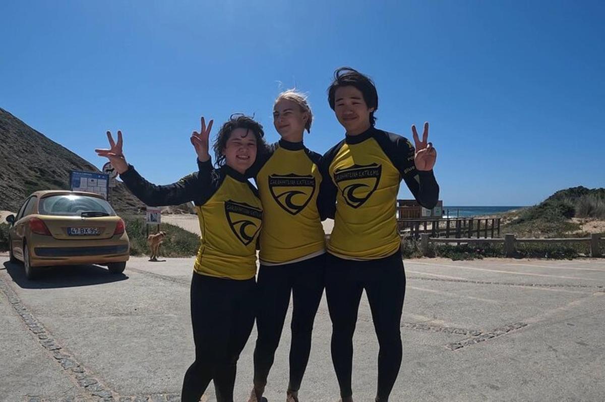 Un grupo de tres mujeres paradas en un estacionamiento.