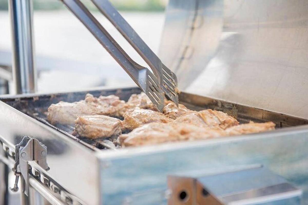 una spatola che cuoce la carne sopra una griglia