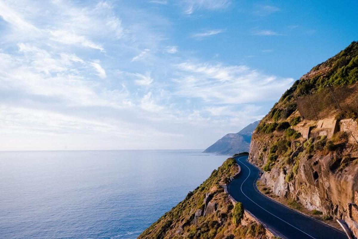 una carretera al costat d'una muntanya al costat de l'oceà