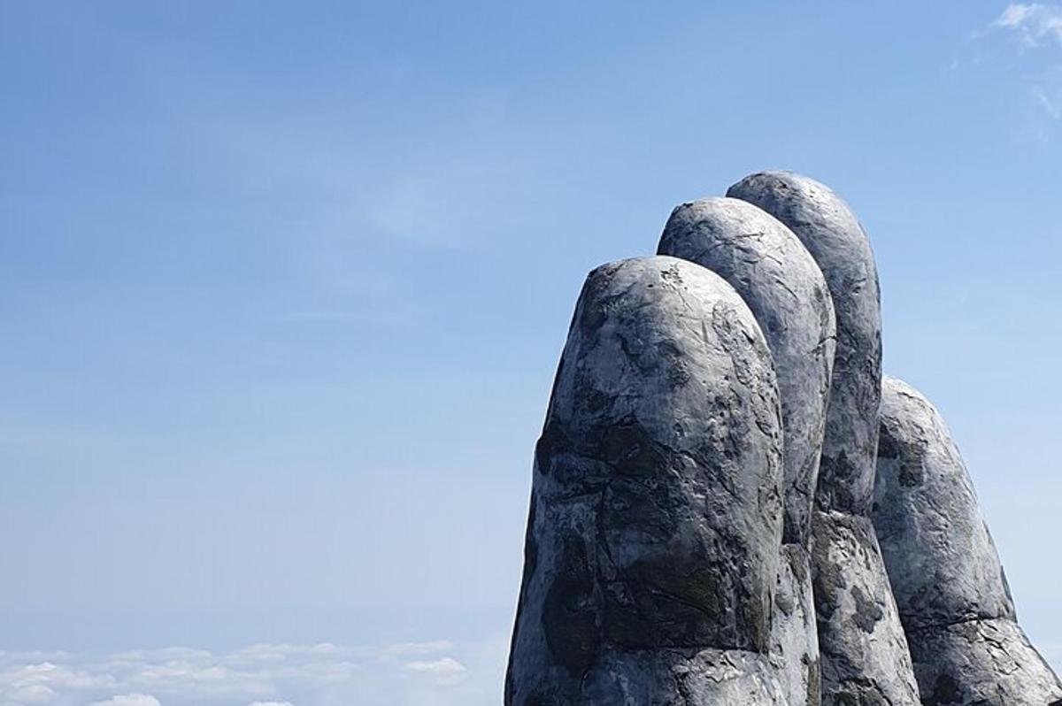 a statue of a pair of hands looking up at the sky